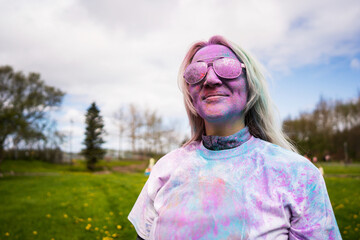 Portrait of happy European woman celebrating Holi with powder colors or gulal.