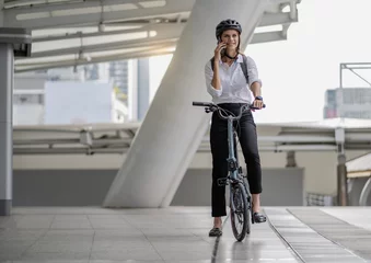 Foto op Aluminium Eco friendly, businesswoman ride bicycle in urban to reduce carbon footprint. Beautiful woman environment preservation person commuting with bicycling. Cycling, alternative transport for clean energy. © Nassorn