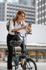 Eco friendly, businesswoman ride bicycle in urban to reduce carbon footprint. Beautiful woman environment preservation person commuting with bicycling. Cycling, alternative transport for clean energy.