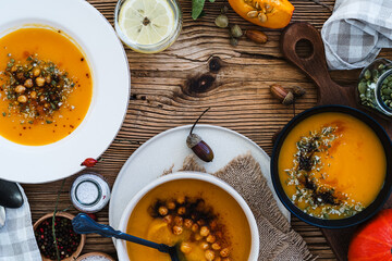 Bowls with vegan pumpkin soup  on wooden table, directly above