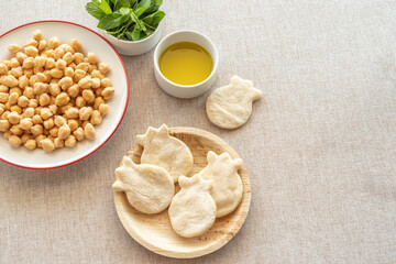 Homemade pita bread in the form of pomegranate, olive oil, fresh mint, chickpeas over cotton fabric...
