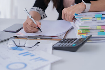 Naklejka premium Business Documents concept : Employee woman hands working in Stacks paper files for searching and checking unfinished 