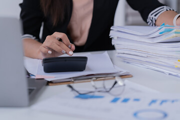 Business Documents concept : Employee woman hands working in Stacks paper files for searching and checking unfinished	