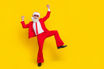 Fototapeta na wymiar Full length photo of positive lucky claus wear red tux costume rising fists empty space isolated yellow color background