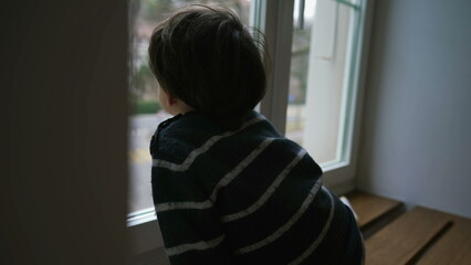 Pensive Little Boy Staring at View from Apartment Window, Deep in Thought