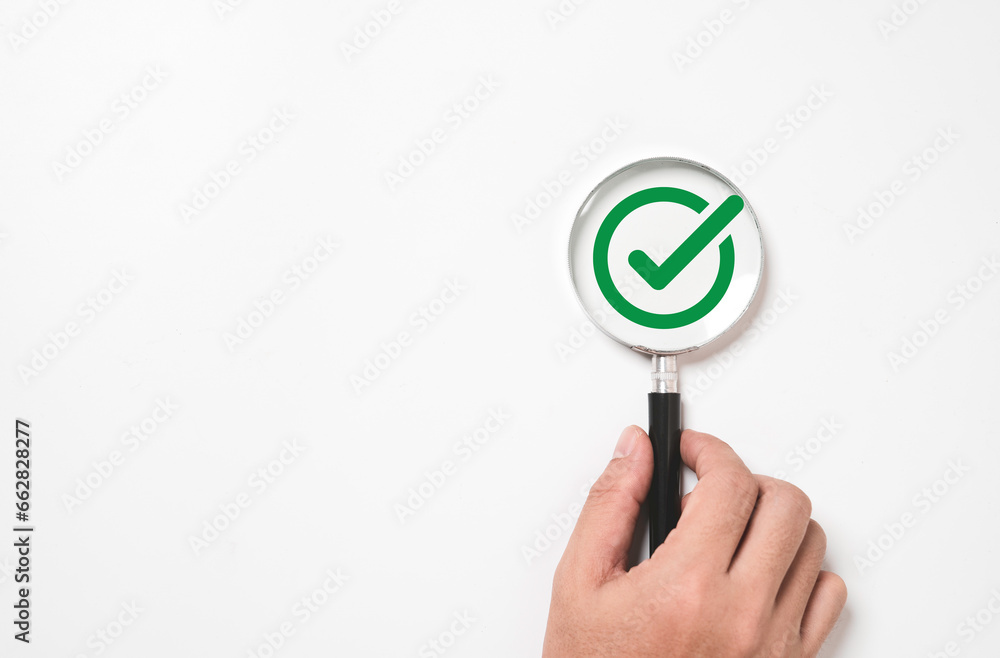 Poster Hand holding magnifier glass with green correct sign or tick mark for document , project approve and accept verification code concept.