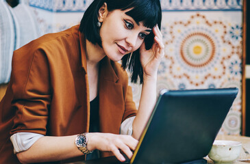 Shocked businesswoman using laptop in cafe