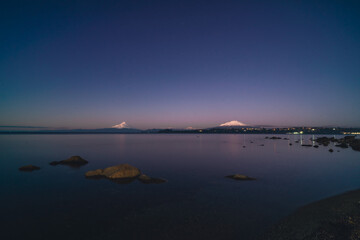 sunset by the lake in puerto varas with volcanos in the background