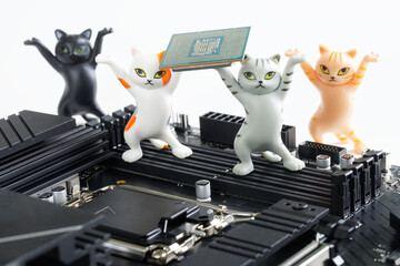 Toy kittens hold computer processor next to the socket for installing it on the motherboard. Assembling, overclocking and upgrading modern computer. Study of computer technologies. Photo.
