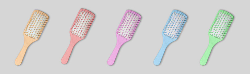 Set of multicolored wooden hair brushes isolated on gray background.