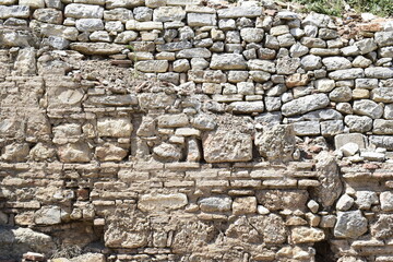 Historical old ancient damaged or severed massive stone and brick mixed style wall