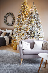 Beautifully luxurious, decorated with garlands and balls, christmas tree and golden gifts, apartment living room decor for merry christmas. There are no people, trendy coziness in the room,