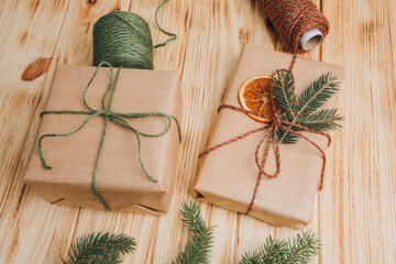 Christmas background. Gift wrapping in brown paper with dry orange and branch of coniferous tree on...