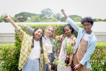 Group of happy Multiethnic teenager friend holding sapling tree, smiling young diverse farmer...