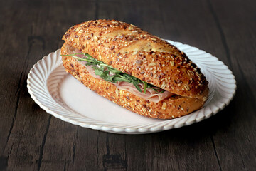 ham and arugula sandwich in a white plate