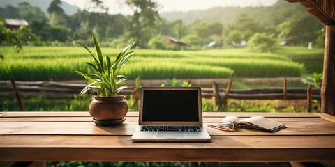 Fotobehang Rijstvelden Paddy fields, a wooden table with a plant vase, a blank laptop screen, and a landscape