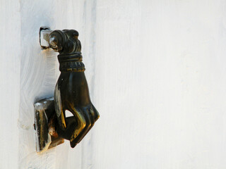 Hand shaped knocker on wooden door