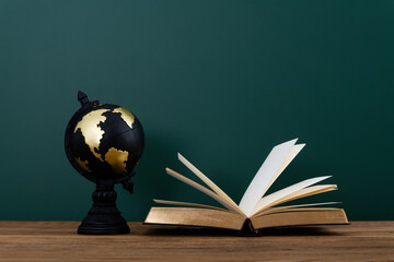 Globe and book in front of the blackboard
