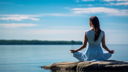 woman meditating on a rock by the lake
