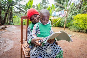 A brother helps his sister with homework in the village in Africa