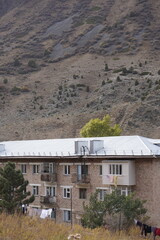 five-story Soviet residential building in the mountains, hills, trees, Soviet architecture