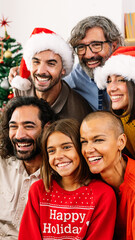 Vertical portrait of happy family in santa hat celebrating christmas together. Large group of...