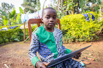 Portrait of an African child studying from the tablet, technology in Africa