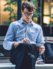  trader checking banking account on tablet using electronic stylus for typing