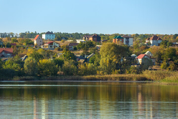 Fototapeta na wymiar Village on the shore of a lake in Ukraine on an autumn sunny day