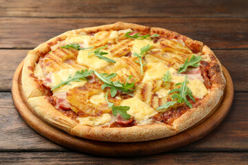 Delicious pineapple pizza with arugula on wooden table