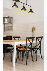 Dining table with chairs under vintage chandelier in kitchen