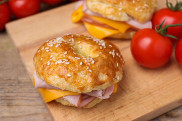 Delicious bagels with ham and cheese on table, closeup