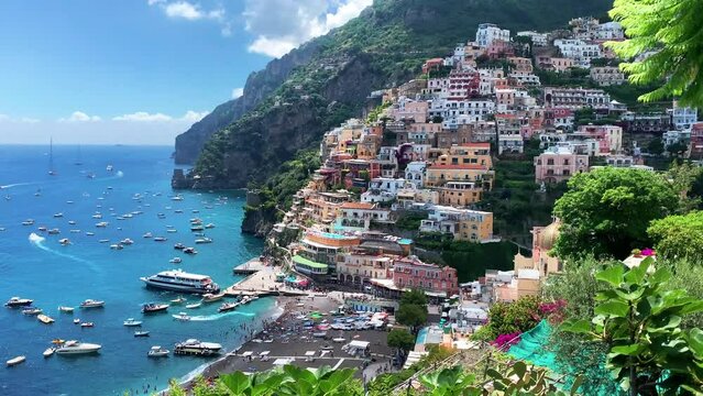 Positano, tourist destination on the Amalfi Coast, Italy. Aerial view of Colorful houses on a Tyrrhenian sea coast seen through green juicy flora in Positano is a village in Naples metropolitan area