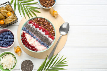Tasty smoothie bowl with fresh berries and granola served on white wooden table, flat lay. Space for text