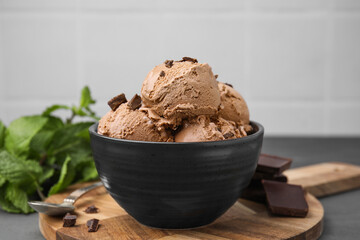 Bowl with tasty chocolate ice cream on wooden board, closeup