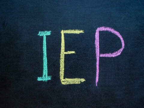 Individualized Education Program IEP written in chalk on blackboard.