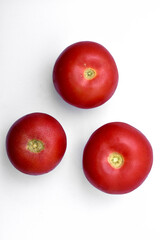 Fototapeta na wymiar Three juicy red tomatoes on a white background.