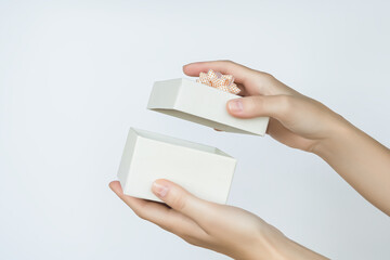 female hands open a cardboard gift box on a white background