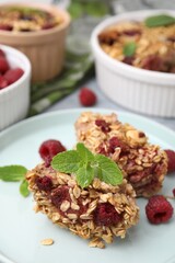 Tasty baked oatmeal with raspberries on table, closeup