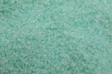 Turquoise sea salt as background, top view