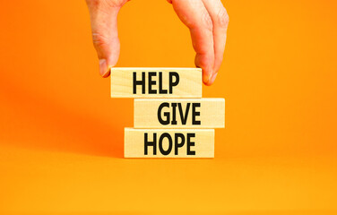 Help give hope symbol. Concept word Help give hope on beautiful wooden block. Businessman hand. Beautiful orange table orange background. Business motivational help give hope concept. Copy space.