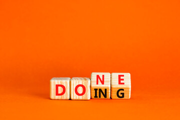 Doing and done symbol. Concept words Doing Done on wooden block. Beautiful orange table orange background. Business doing and done concept. Copy space. © Dzmitry