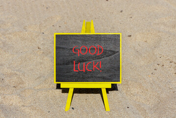 Good luck symbol. Concept words Good luck on beautiful black chalk blackboard. Beautiful sea sand beach background. Business, motivational good luck concept. Copy space.