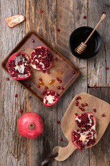 Fresh, ripe pomegranate, opened with seeds spilling out on a wooden background