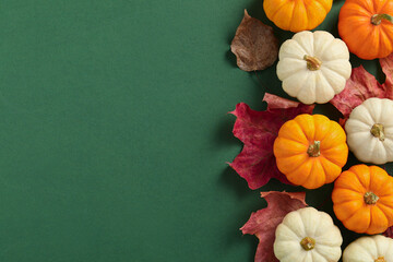Happy Thanksgiving day. Flat lay composition with pumpkins on green background, space for text