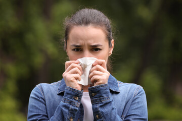 Woman suffering from seasonal spring allergy outdoors