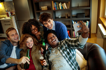 Young and diverse group of friends taking selfies on a get together at home