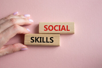 Social skills symbol. Wooden blocks with words Social skills Beautiful pink background. Businessman hand. Business and Social skills concept. Copy space.