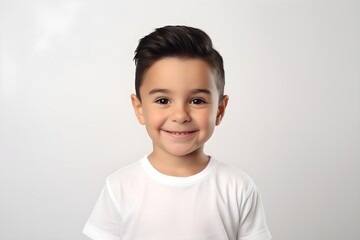 Portrait of boy in white t-shirt on gray background.