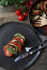 Delicious ratatouille served with basil on wooden table, flat lay
